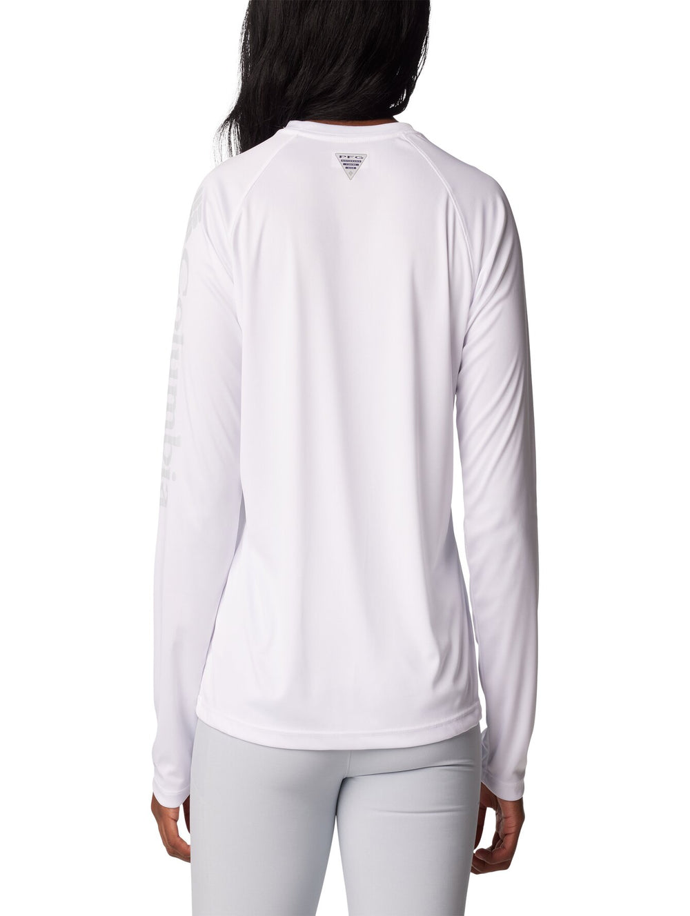 Mujer vistiendo una camiseta deportiva de manga larga color blanco de la marca Columbia.
