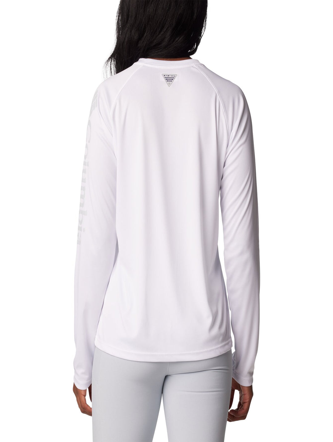Mujer vistiendo una camiseta deportiva de manga larga color blanco de la marca Columbia.