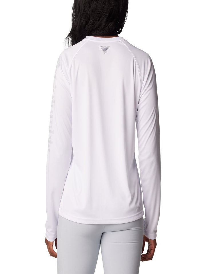 Mujer vistiendo una camiseta deportiva de manga larga color blanco de la marca Columbia.