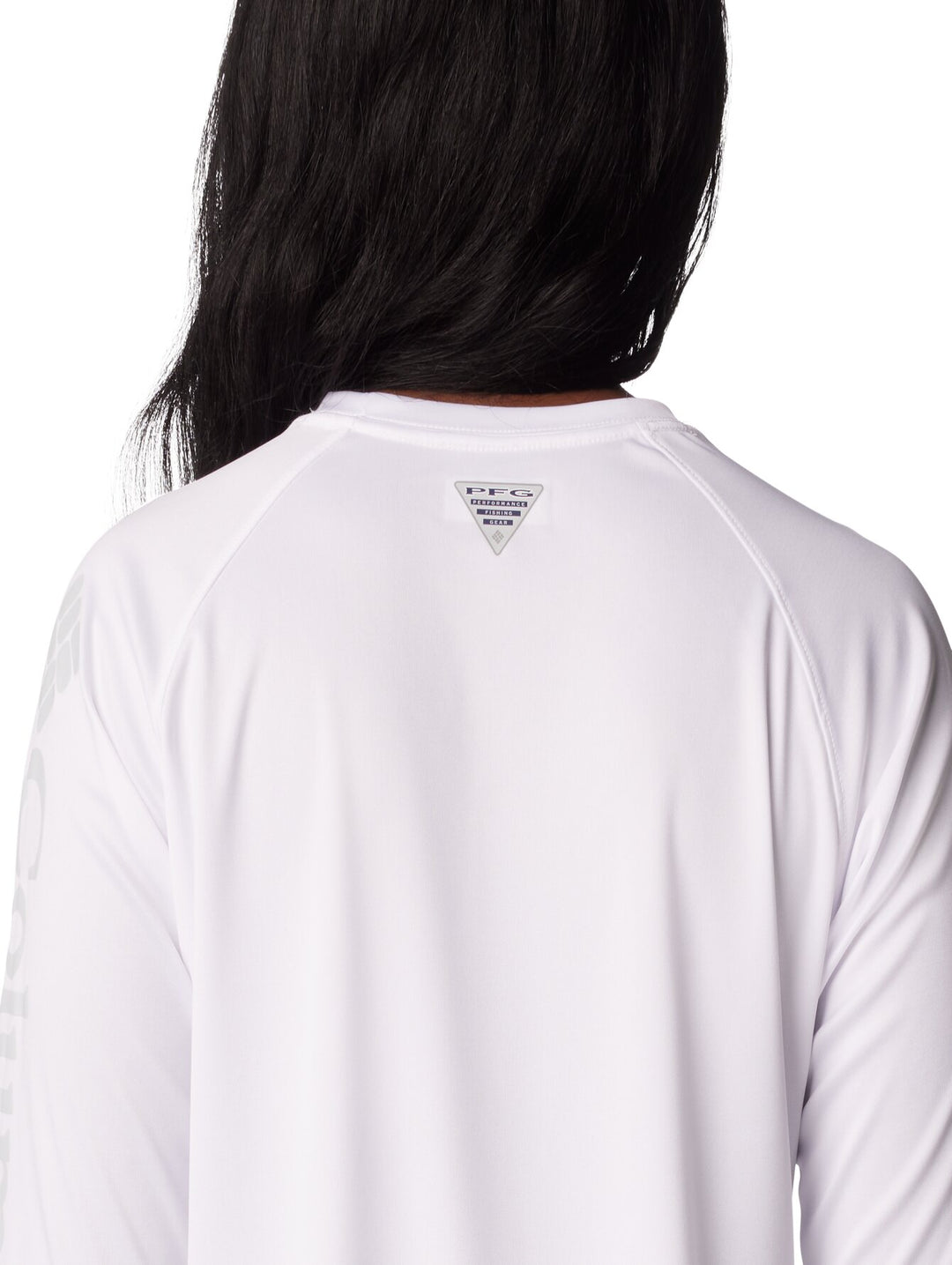 Mujer vistiendo una camiseta deportiva de manga larga color blanco de la marca Columbia.