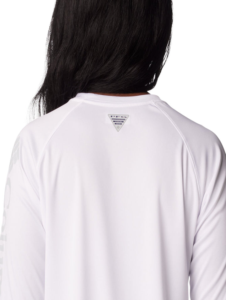Mujer vistiendo una camiseta deportiva de manga larga color blanco de la marca Columbia.