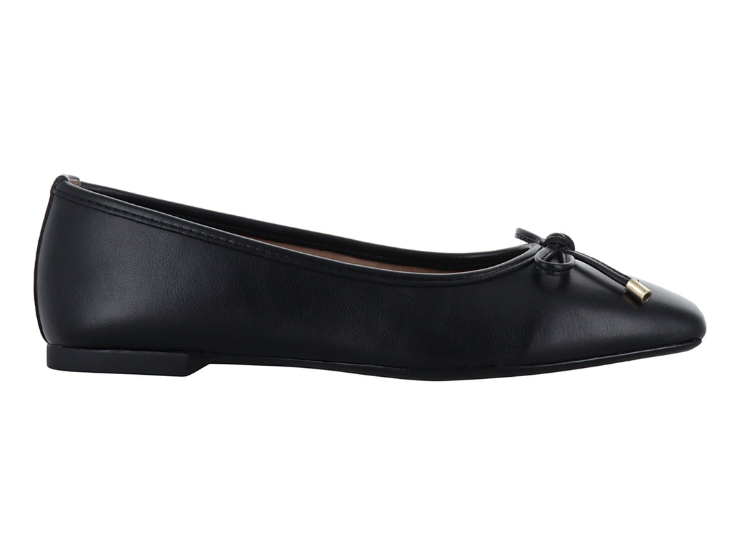 Zapato plano color negro para mujer con un pequeño moño y detalles dorados en la punta.