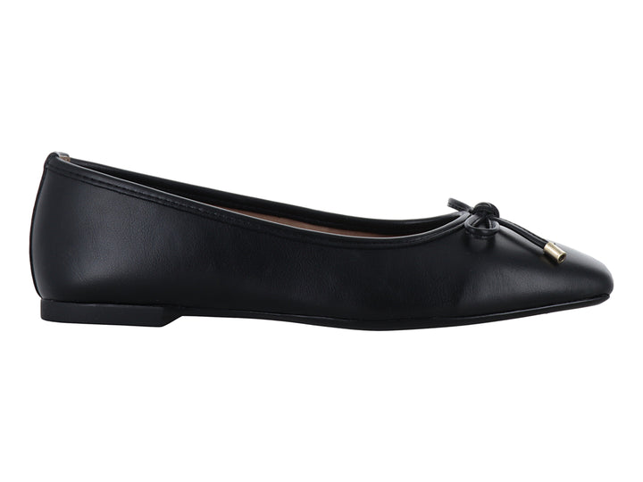 Zapato plano color negro para mujer con un pequeño moño y detalles dorados en la punta.