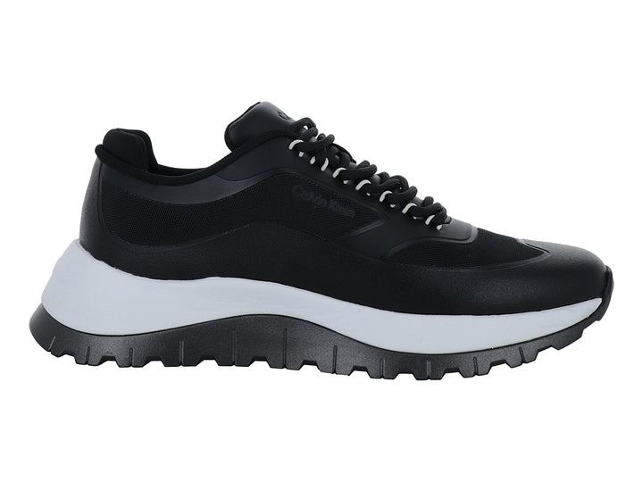 Tenis Calvin Klein color negro con suela gruesa bicolor en blanco y negro y cierre de cordones.