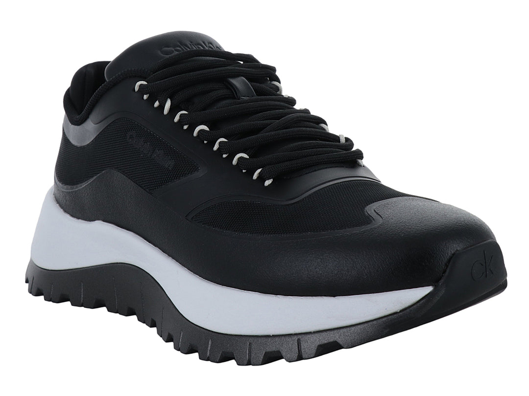 Tenis Calvin Klein color negro con suela gruesa bicolor en blanco y negro y cierre de cordones.