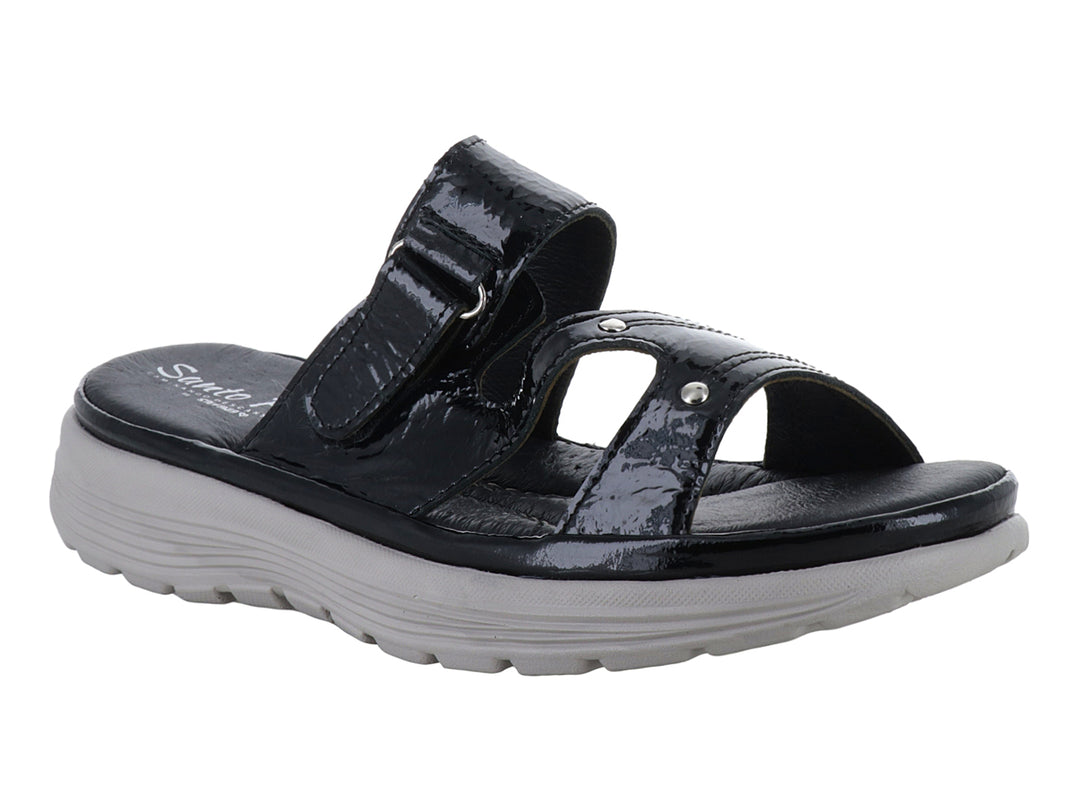 Sandalia negra de charol con suela gris gruesa y correa ajustable.
