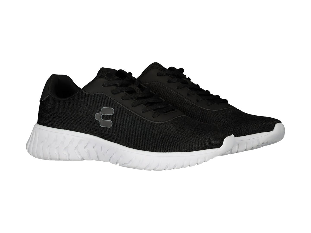 Tenis deportivos Charly en color negro con suela blanca ondulada y agujetas negras.