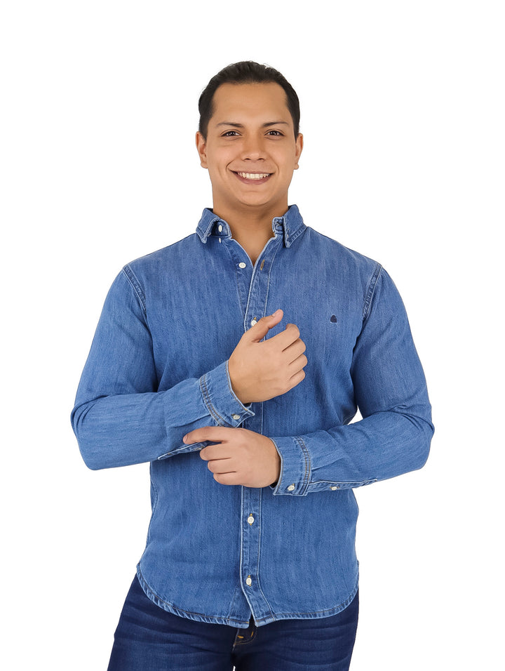 Hombre vistiendo una camisa de mezclilla azul de manga larga con botones frontales.