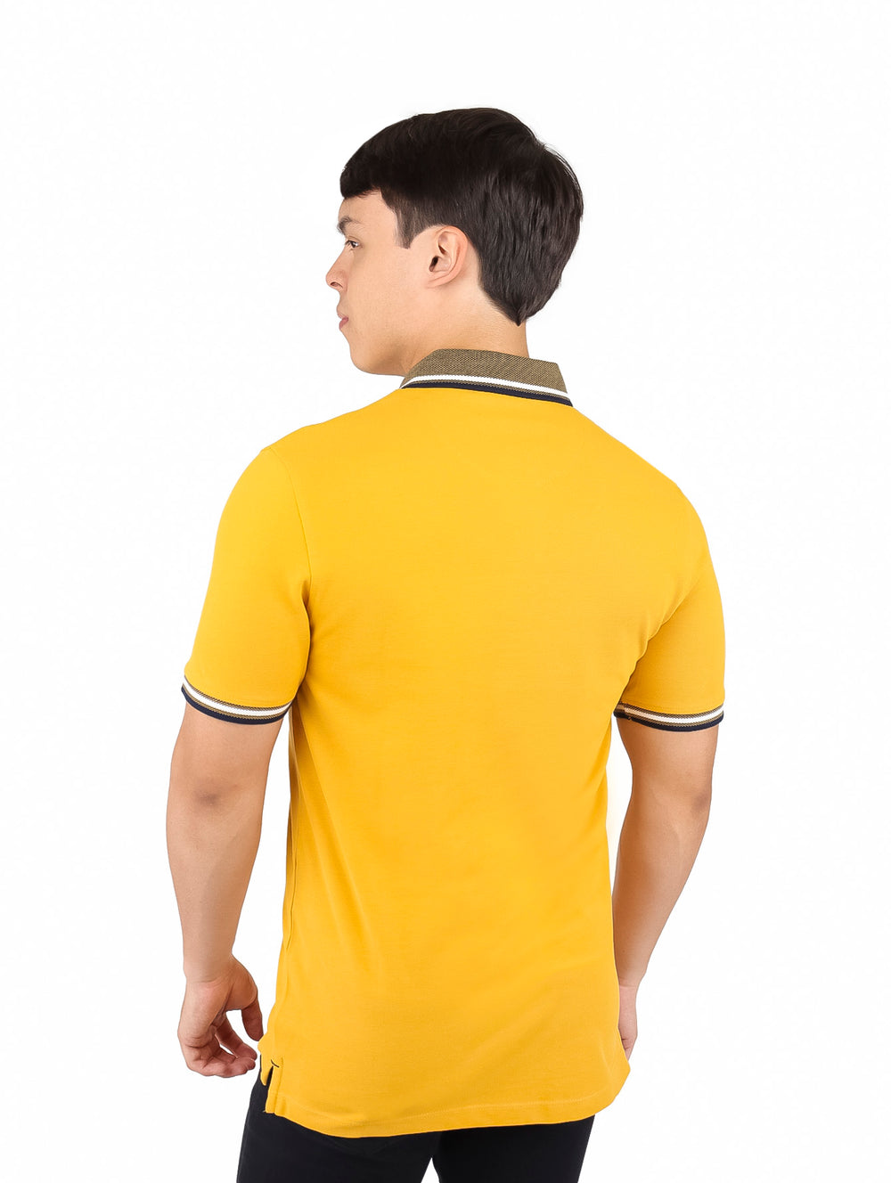 Hombre vistiendo una camiseta polo color amarillo miel con detalles contrastantes en el cuello y las mangas.