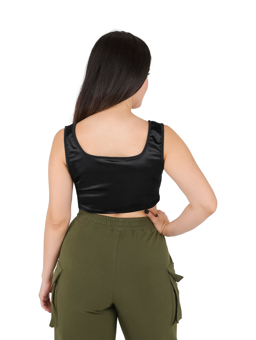 Mujer vistiendo un croptop negro brillante sin mangas con cuello cuadrado y pantalones cargo verde oliva.