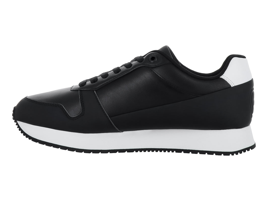 Tenis Calvin Klein color negro con suela blanca y detalles en el talón, estilo retro runner.