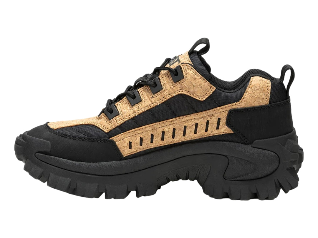 Tenis Caterpillar color negro y beige con detalles de corcho y suela robusta.
