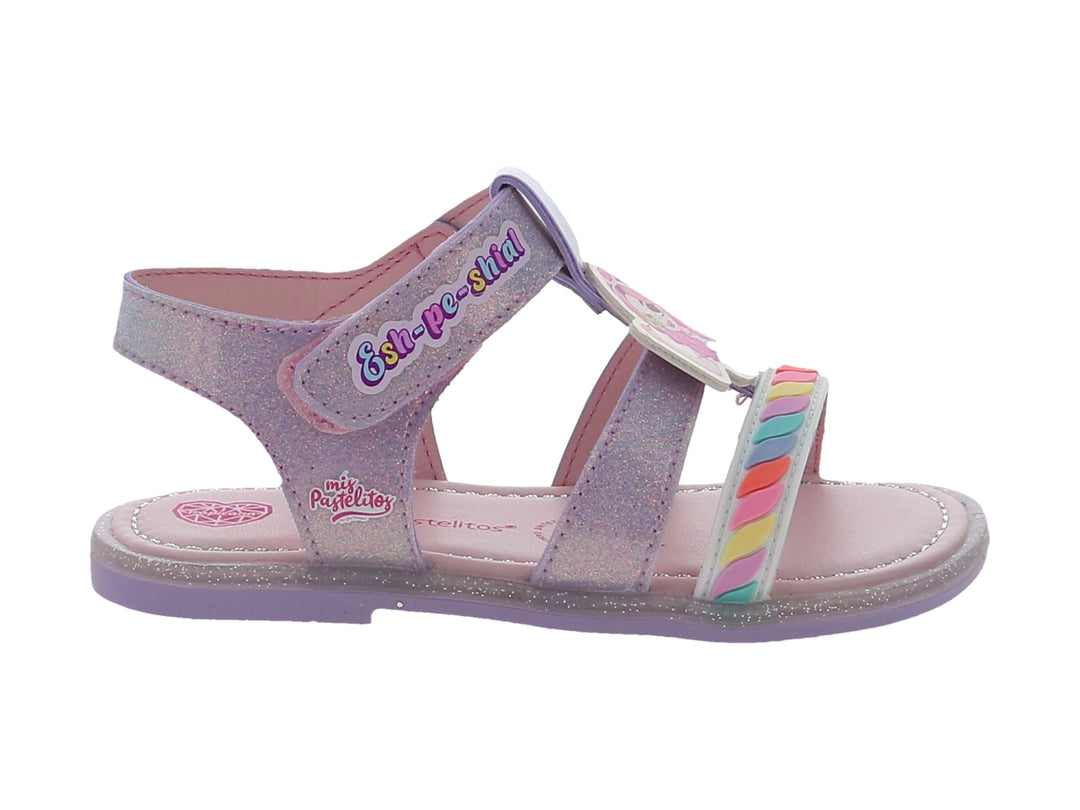 Sandalia infantil color lila con acabado brillante, detalles de arcoíris y correa con texto decorativo.