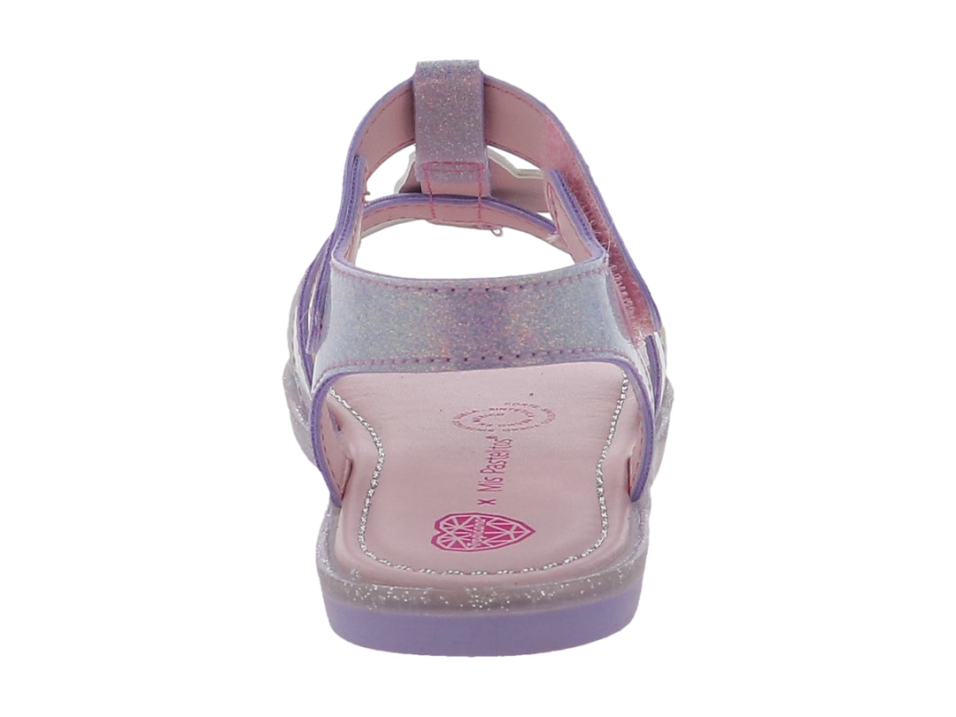 Sandalia infantil color lila con acabado brillante, detalles de arcoíris y correa con texto decorativo.