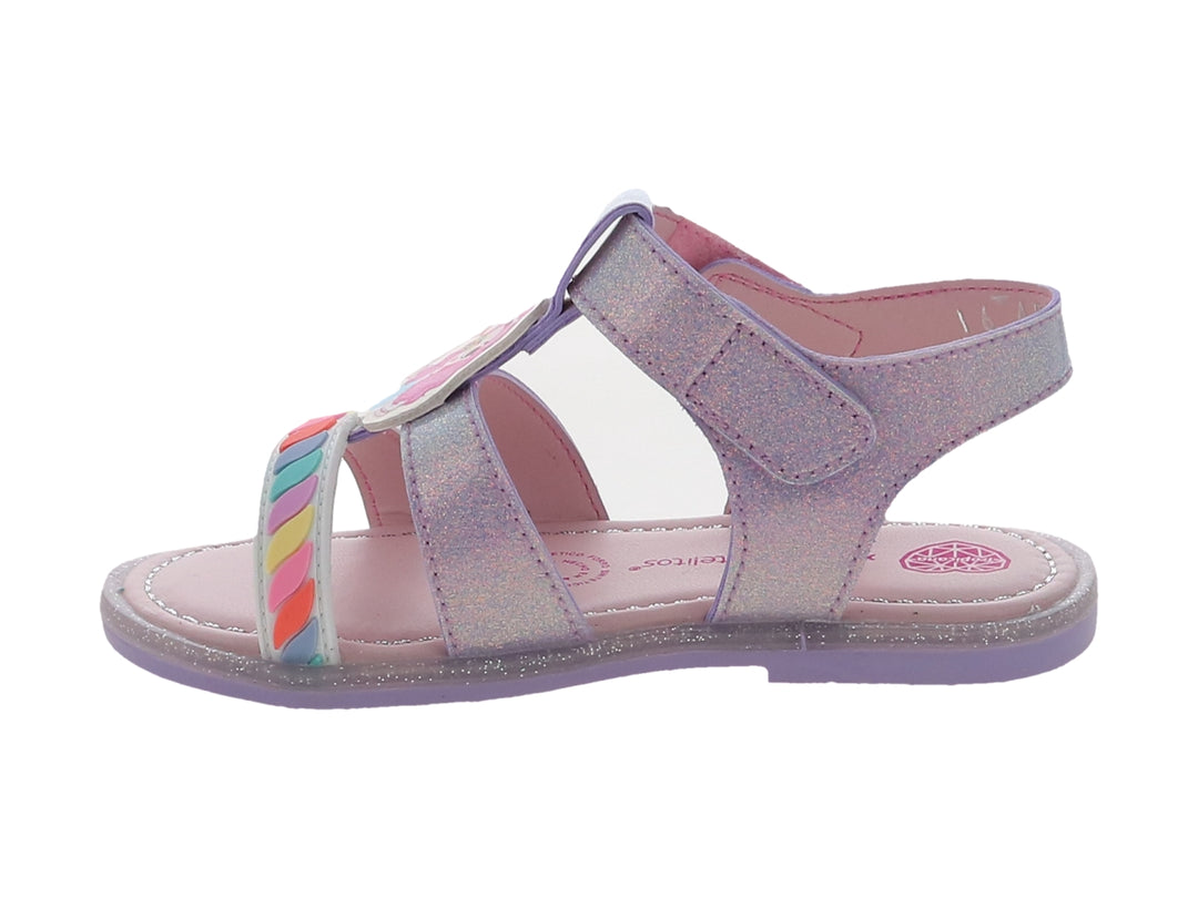Sandalia infantil color lila con acabado brillante, detalles de arcoíris y correa con texto decorativo.