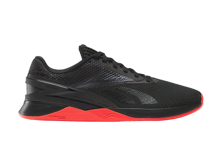 Tenis deportivos Reebok Nano X3 color negro con suela en tono rojo neón.