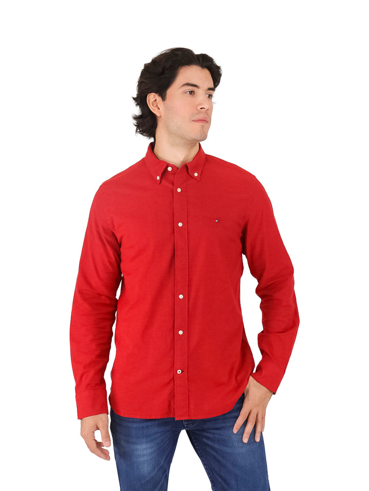 Hombre vistiendo una camisa Tommy Hilfiger de color rojo con botones y manga larga.