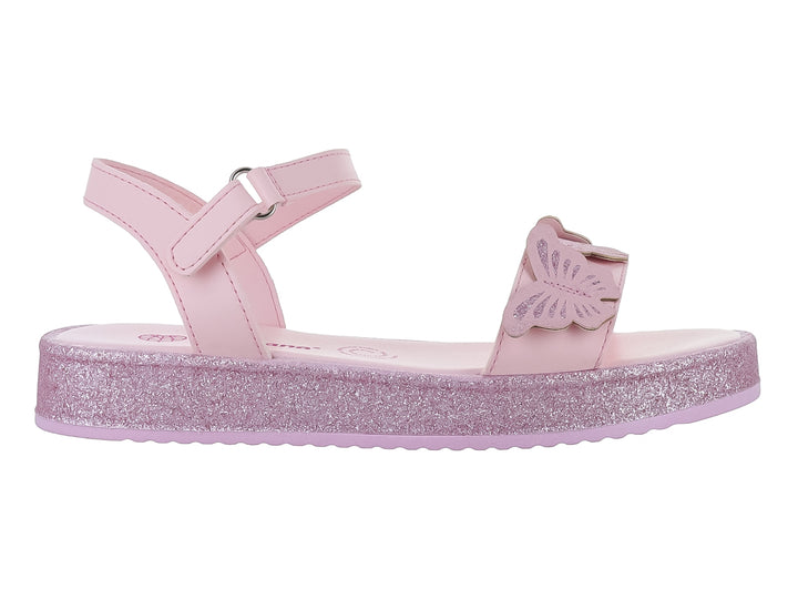 Sandalia rosa claro para niña con suela brillante de glitter y detalle de mariposa en la parte frontal.