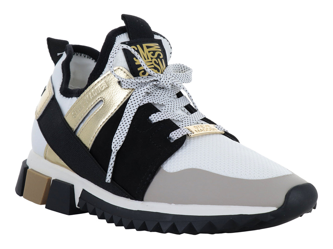 Tenis Steve Madden modelo Decend en colores blanco, negro y dorado con suela gruesa dentada.