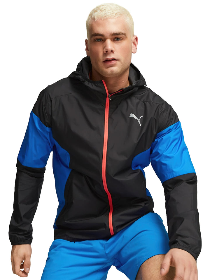 Chaqueta deportiva PUMA ligera en colores negro y azul con capucha y cierre frontal rojo.