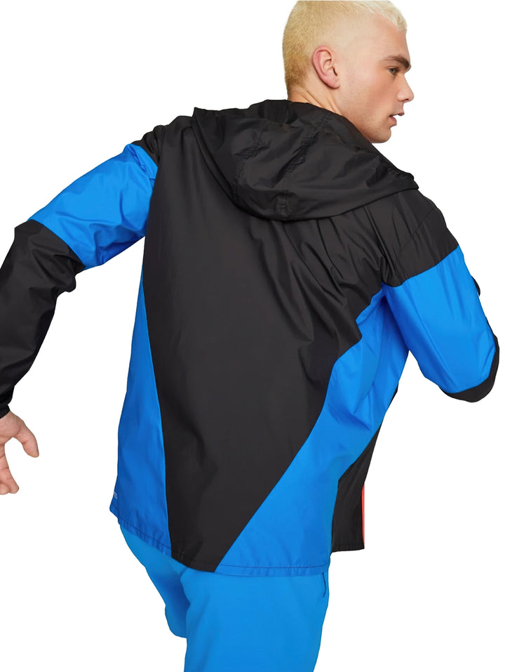 Chaqueta deportiva PUMA ligera en colores negro y azul con capucha y cierre frontal rojo.