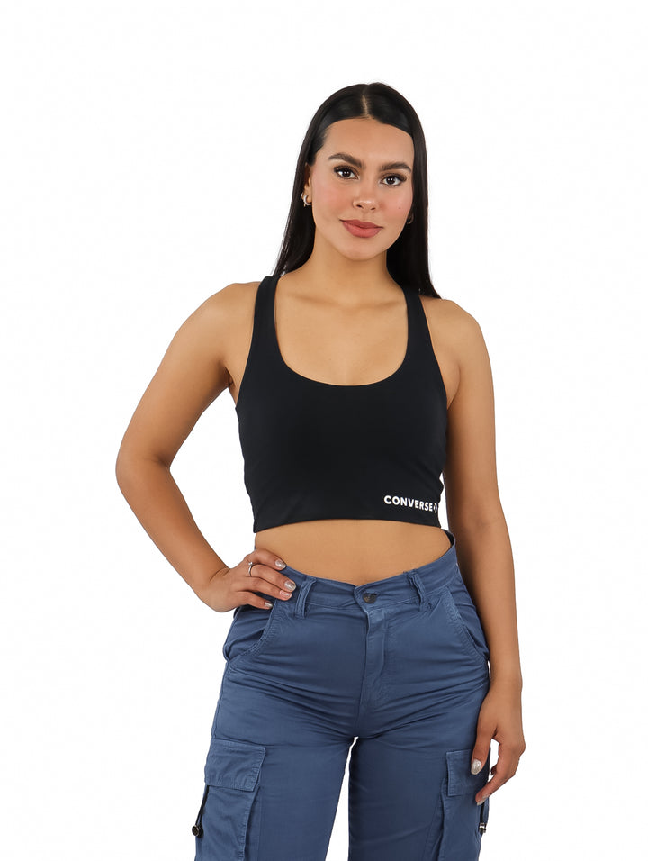 Mujer vistiendo un bra top corto de color negro con el logo de Converse en blanco.