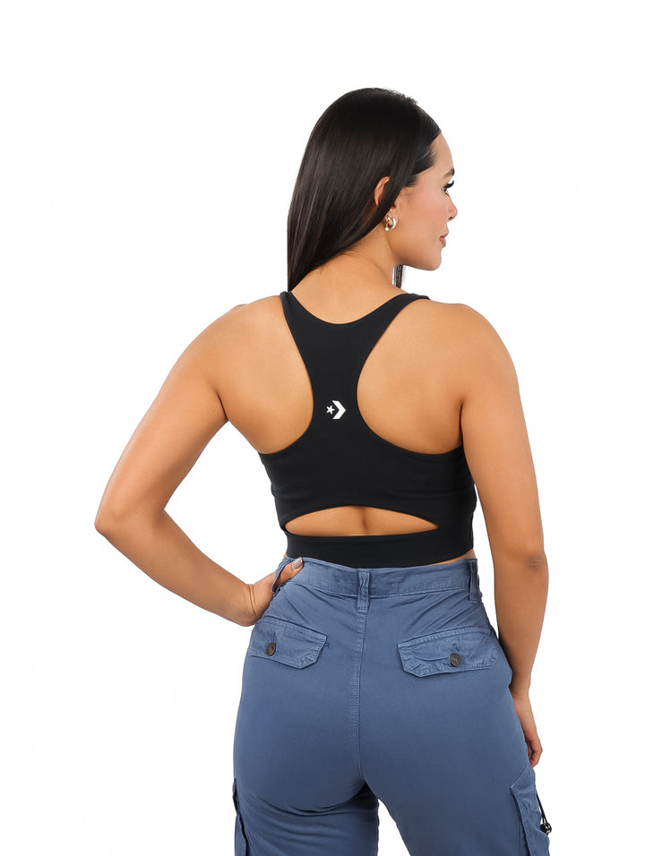Mujer vistiendo un bra top corto de color negro con el logo de Converse en blanco.