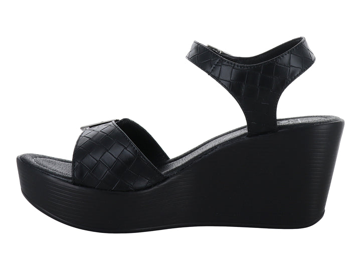 Sandalia de plataforma color negro con textura de piel de cocodrilo y hebillas plateadas.