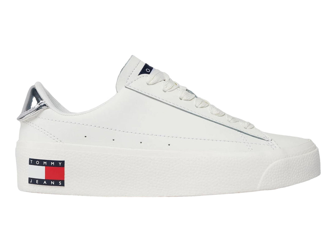 Tenis Tommy Hilfiger color ecru con suela de plataforma blanca y detalle plateado en el talón.