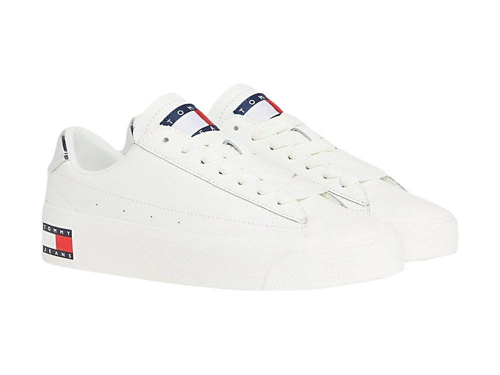 Tenis Tommy Hilfiger color ecru con suela de plataforma blanca y detalle plateado en el talón.