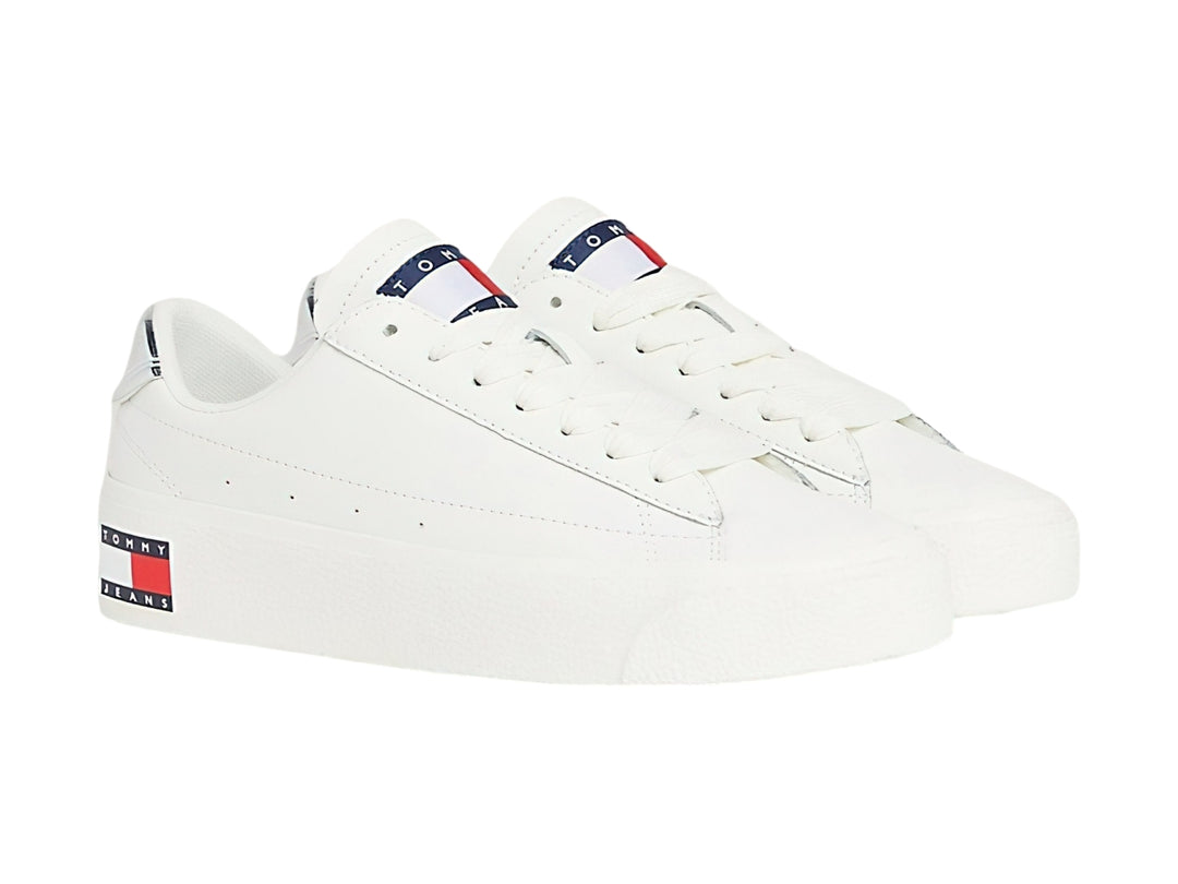 Tenis Tommy Hilfiger color ecru con suela de plataforma blanca y detalle plateado en el talón.