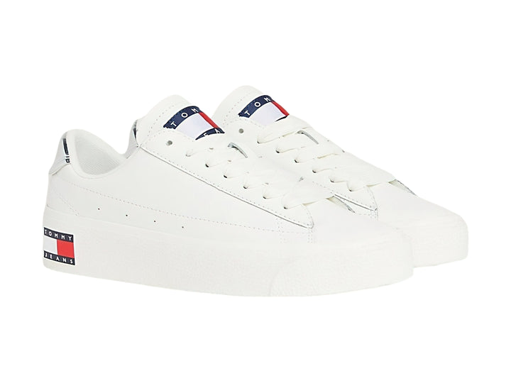 Tenis Tommy Hilfiger color ecru con suela de plataforma blanca y detalle plateado en el talón.
