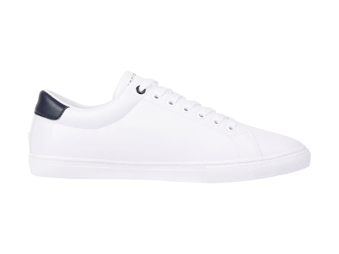 Tenis blancos de Tommy Hilfiger con detalle en azul marino en el talón y suela blanca.
