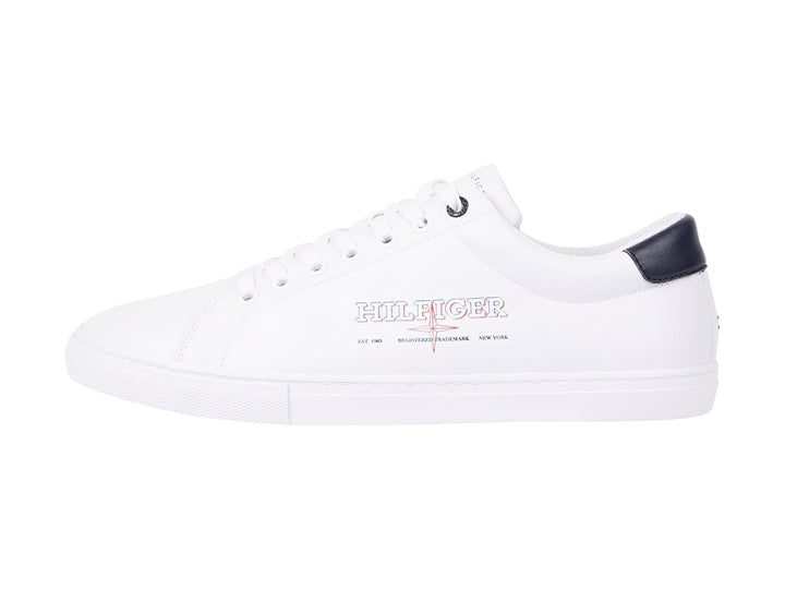 Tenis blancos de Tommy Hilfiger con detalle en azul marino en el talón y suela blanca.