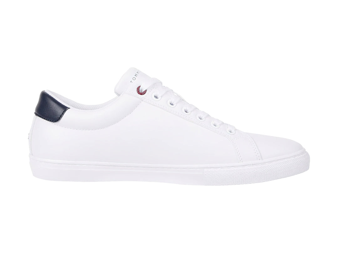 Tenis blancos Tommy Hilfiger con detalle en azul marino en el talón y suela blanca.