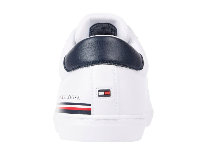 Tenis blancos Tommy Hilfiger con detalle en azul marino en el talón y suela blanca.
