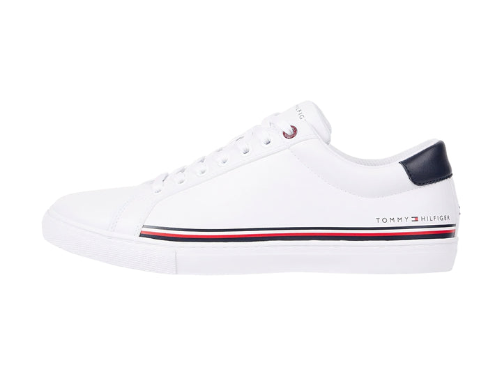 Tenis blancos Tommy Hilfiger con detalle en azul marino en el talón y suela blanca.