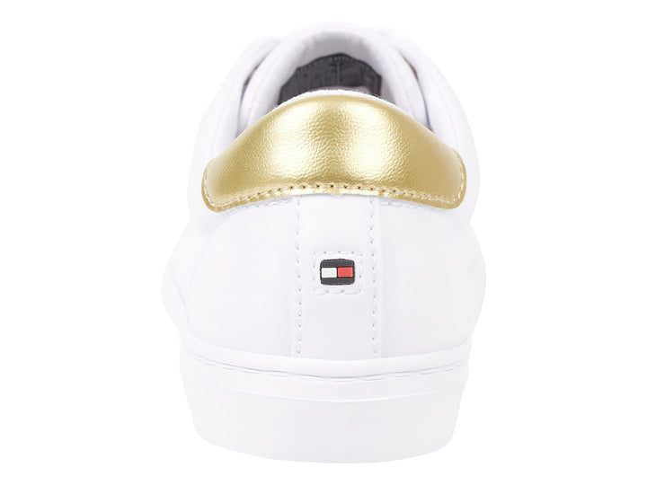 Tenis blancos de corte bajo con detalle dorado en el talón y cordones blancos.