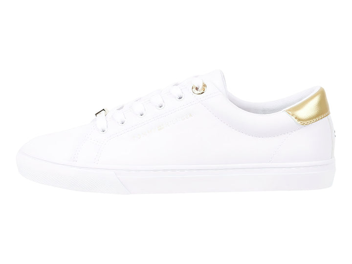 Tenis blancos de corte bajo con detalle dorado en el talón y cordones blancos.