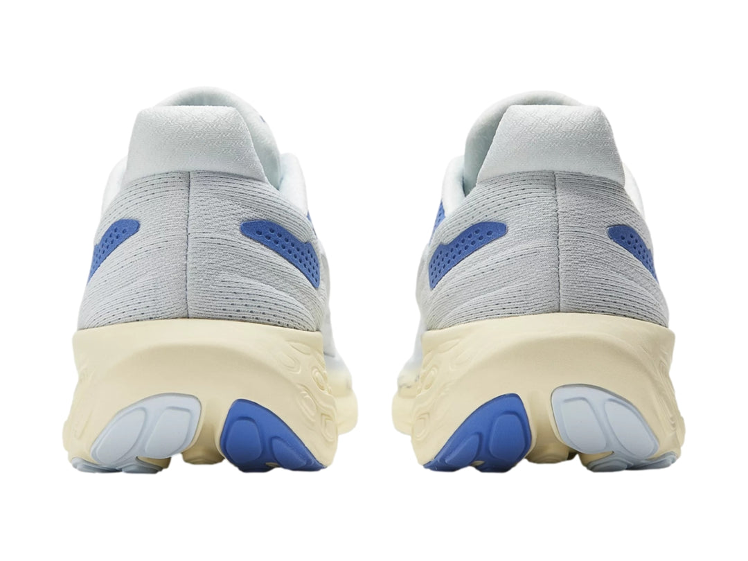 Tenis deportivos New Balance color blanco con detalles en azul y suela gruesa color crema.