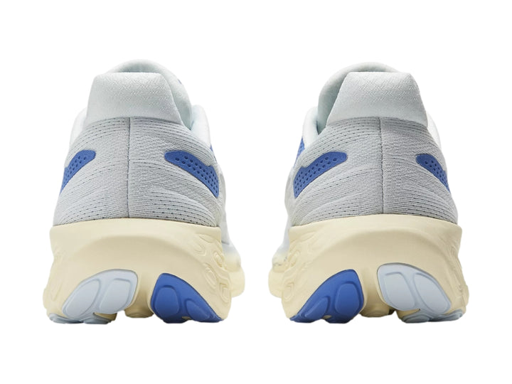 Tenis deportivos New Balance color blanco con detalles en azul y suela gruesa color crema.