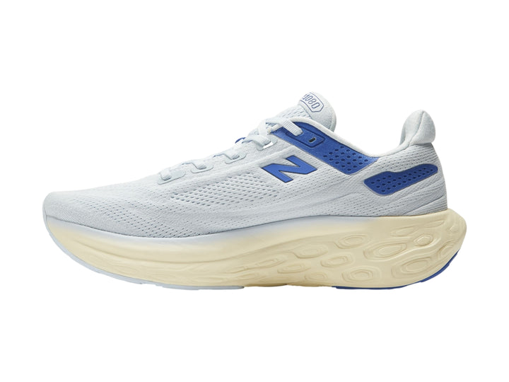Tenis deportivos New Balance color blanco con detalles en azul y suela gruesa color crema.
