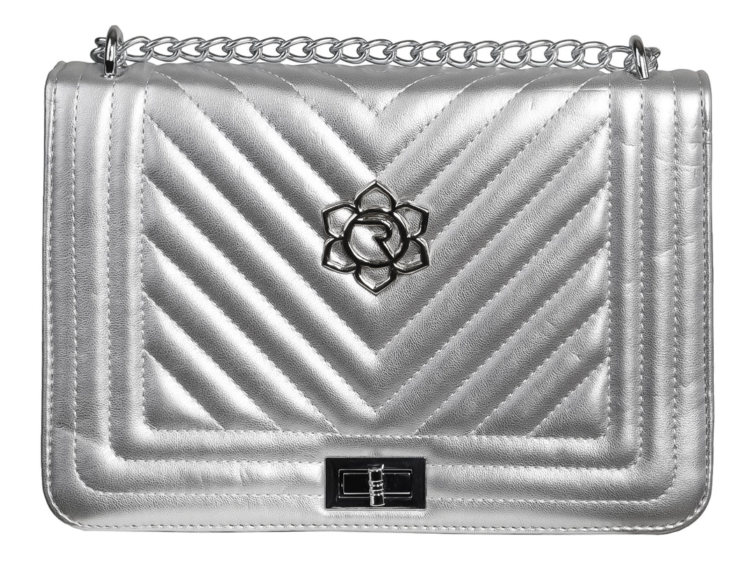 Bolso de hombro color plata con diseño acolchado en chevron, asa de cadena y detalle floral central.