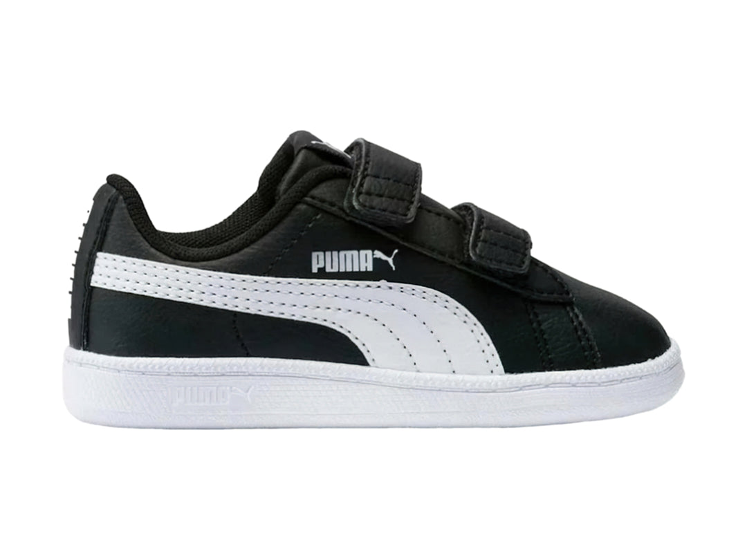 Tenis PUMA infantiles en color negro con franja lateral y suela blancas, cierre mediante correas de velcro.