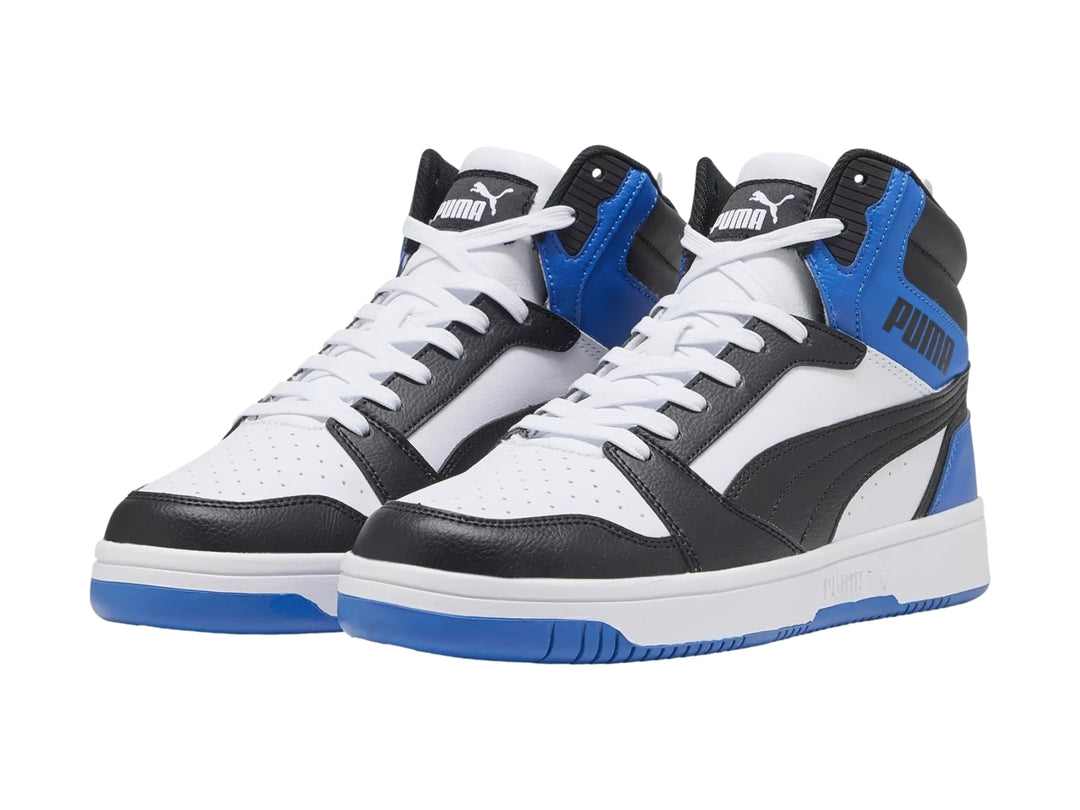 Tenis PUMA Rebound V6 de corte alto en colores blanco, negro y azul royal con suela blanca.