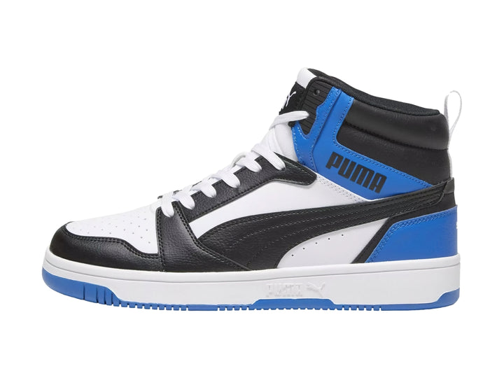 Tenis PUMA Rebound V6 de corte alto en colores blanco, negro y azul royal con suela blanca.