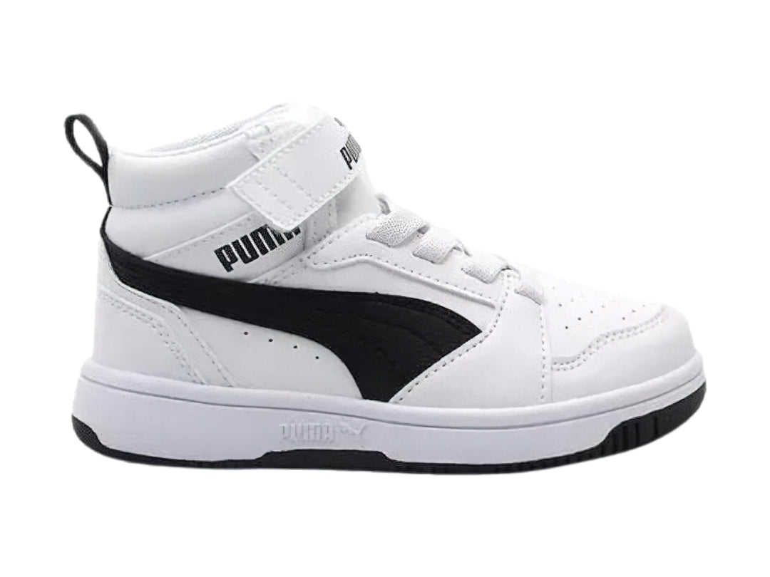 Tenis PUMA Rebound V6 Mid AC+PS en color blanco con franja negra lateral y cierre de velcro, para niño.