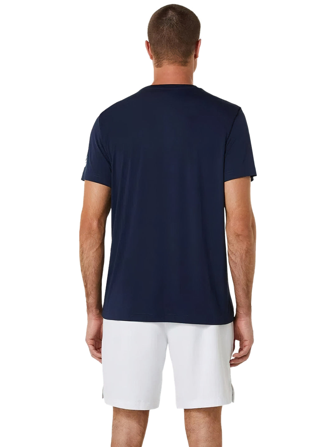 Hombre vistiendo playera deportiva azul marino ASICS y shorts blancos.