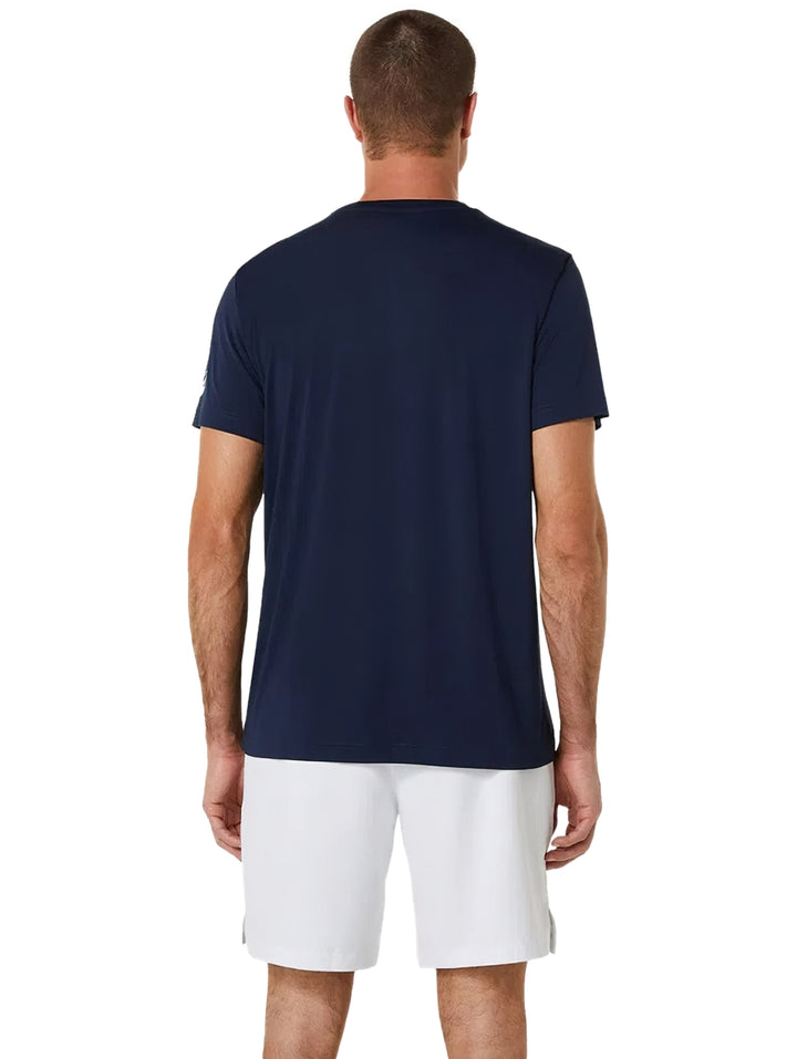 Hombre vistiendo playera deportiva azul marino ASICS y shorts blancos.