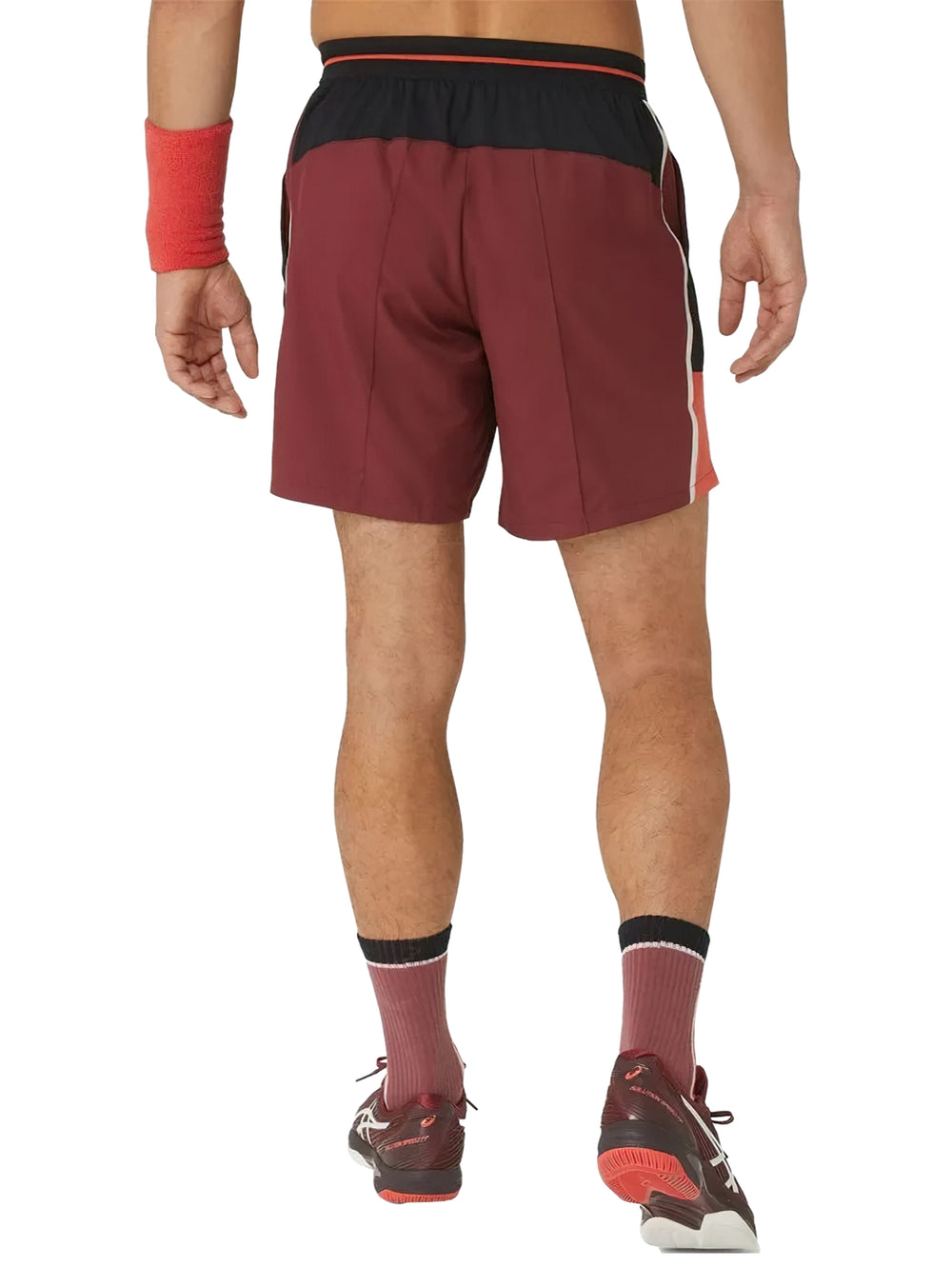 Hombre vistiendo shorts deportivos ASICS color rojo antique red con franjas laterales negras.